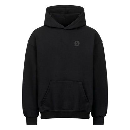 Nahaufnahme des AXTRØNIK Ø Logos als hochwertiger tonaler Stick auf der Brust eines schwarzen 380 GSM Heavyweight Hoodies.