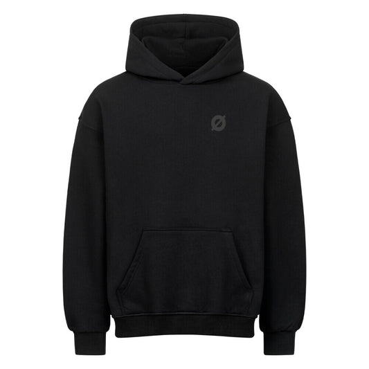 Nahaufnahme des AXTRØNIK Ø Logos als hochwertiger tonaler Stick auf der Brust eines schwarzen 380 GSM Heavyweight Hoodies.